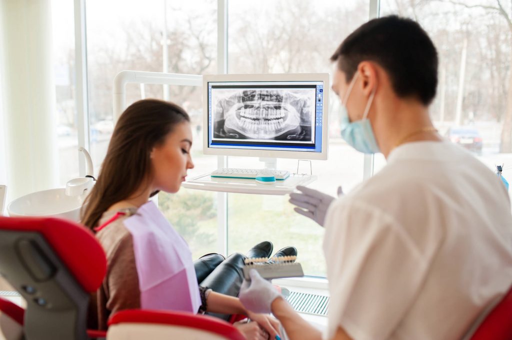 dentist in Clayton explaining dental implant surgery to patient