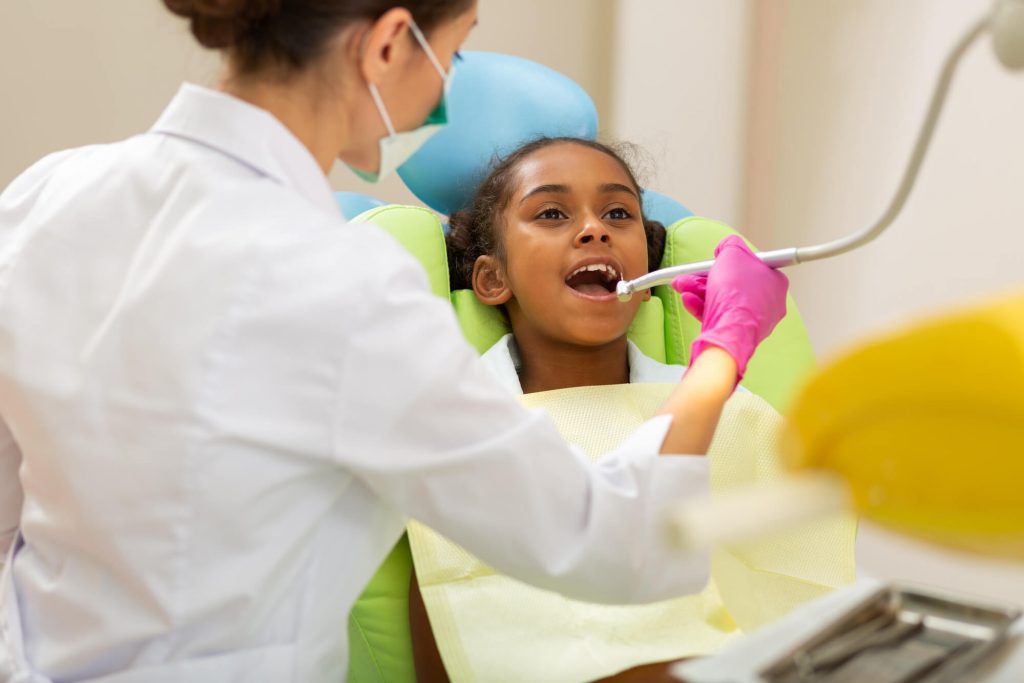 pediatric dentist in Zebulon assessing children's teeth for cavities
