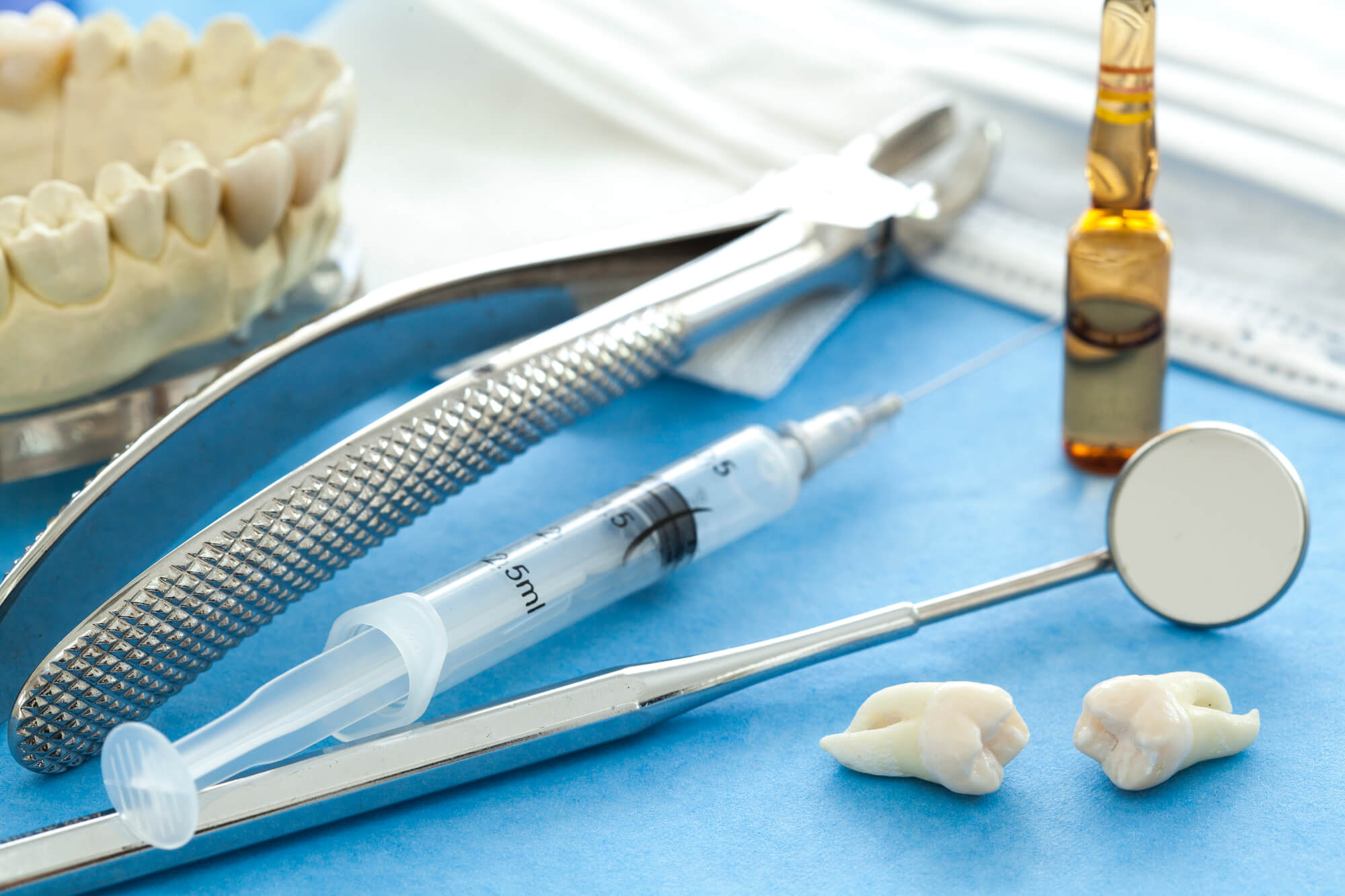 Extracted tooth with tools at a family dentist in Raleigh