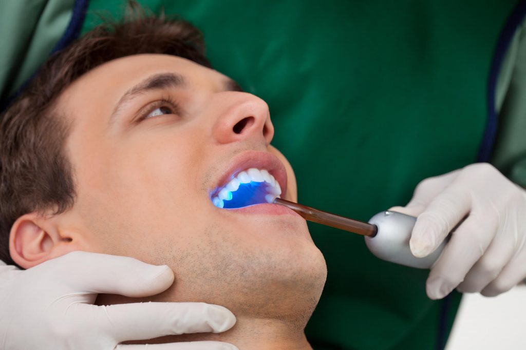 dentist in Raleigh whitening a patients teeth