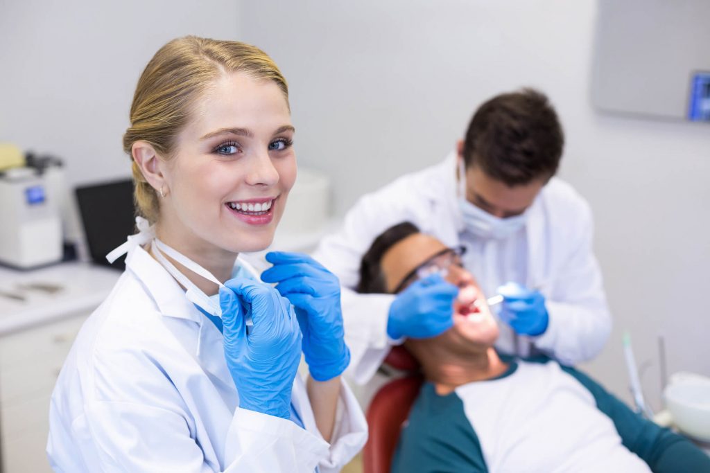dentist in Wendell with patient and dental hygienist in the background